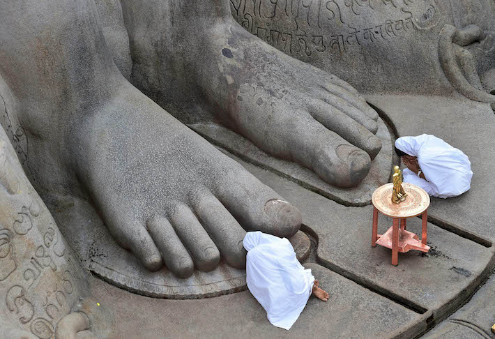Doing pranam to the feet of Bahubali